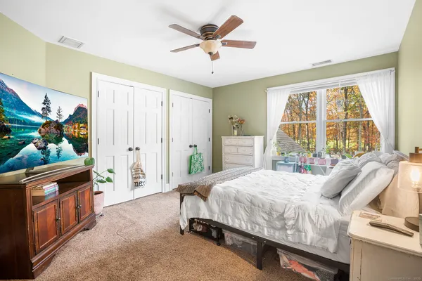 a bedroom with a bed and a large window with the outer view