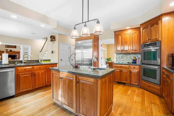 a kitchen with stainless steel appliances granite countertop a stove a sink and a microwave