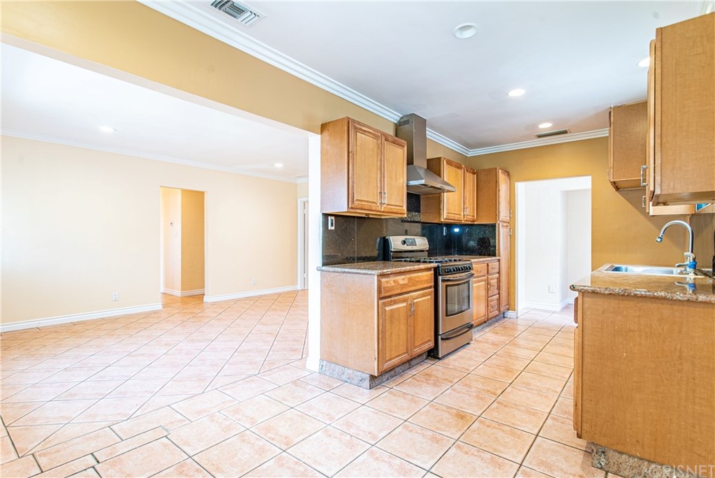 6839 Tampa Avenue Reseda, CA 91335 - Photo 11 of 48 a kitchen with stainless steel appliances granite countertop a stove a sink and a refrigerator