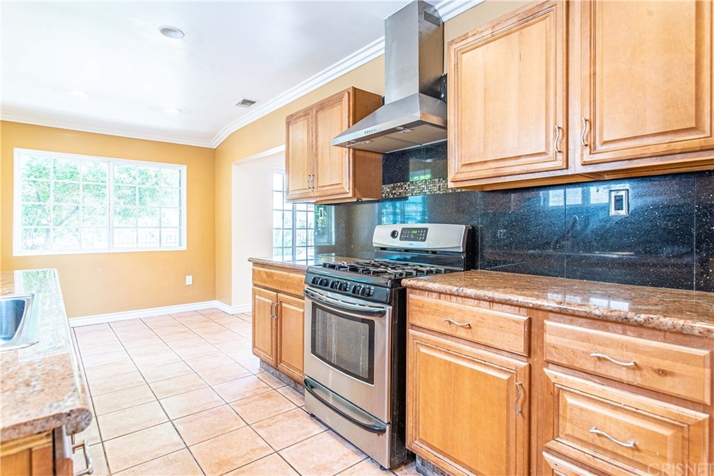 6839 Tampa Avenue Reseda, CA 91335 - Photo 14 of 48 a kitchen with stainless steel appliances granite countertop a stove a sink and a microwave
