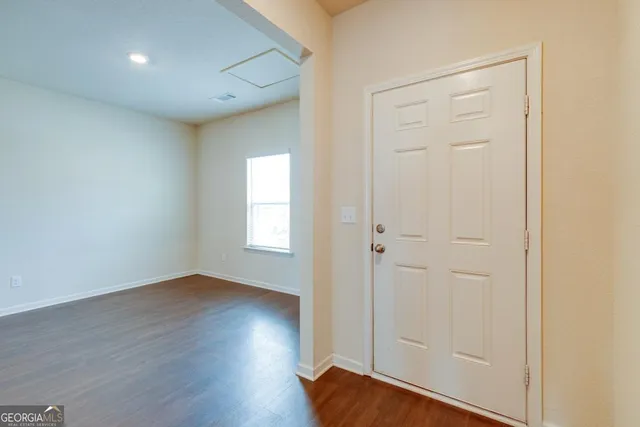 an empty room with wooden floor and closet area