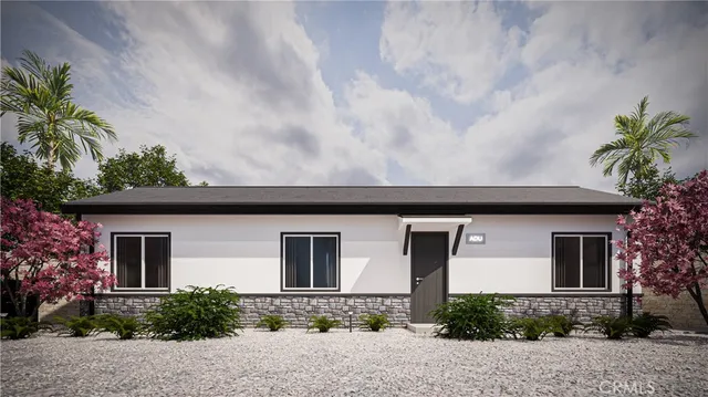 a front view of a house with plants and trees