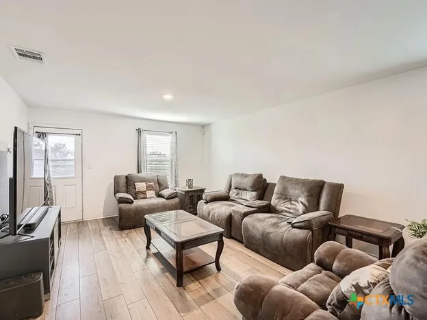 a living room with furniture a couch and a flat screen tv