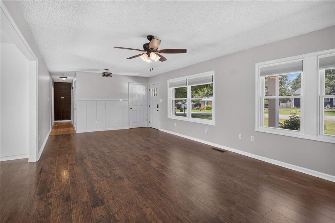 113 Greenfield Avenue Pendleton, SC 29670 - Photo 5 of 40 Rich hardwood-style flooring extends through this airy living space, illuminated by multiple windows.