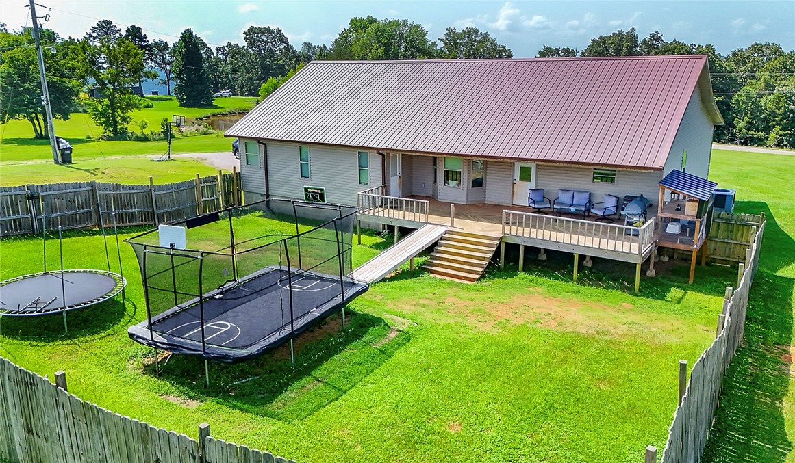 3726 St Joe Road Atkins, AR 72823 - Photo 3 of 41 Rear exterior featuring a spacious wooden deck with railings, a metal roof, and a fenced yard