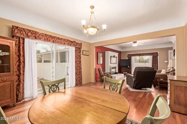 a dining room with wooden floor furniture and a chandelier