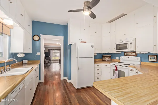 a kitchen with a refrigerator a stove top oven a sink dishwasher and wooden floor
