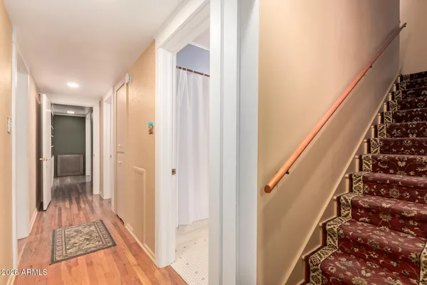 a view of a hallway with wooden floor and staircase