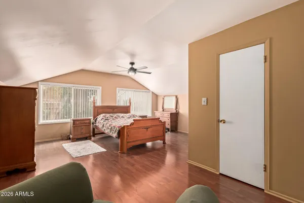 a bedroom with a bed and wooden floor