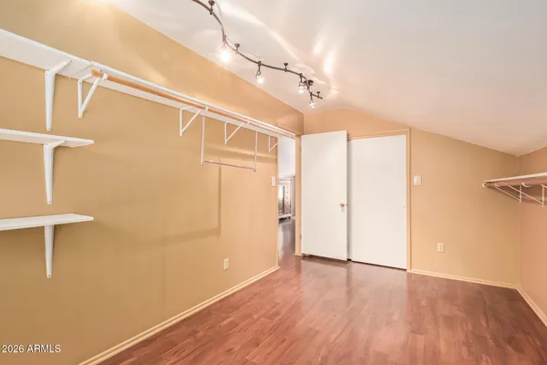 a view of walk in closet with empty racks
