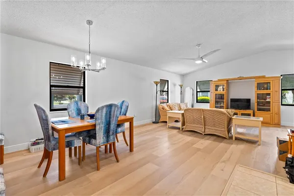 a dining room with furniture wooden floor a rug and a chandelier