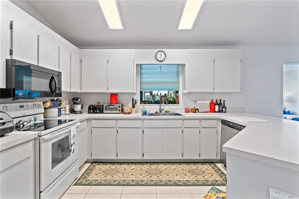 a kitchen with white cabinets sink and white appliances