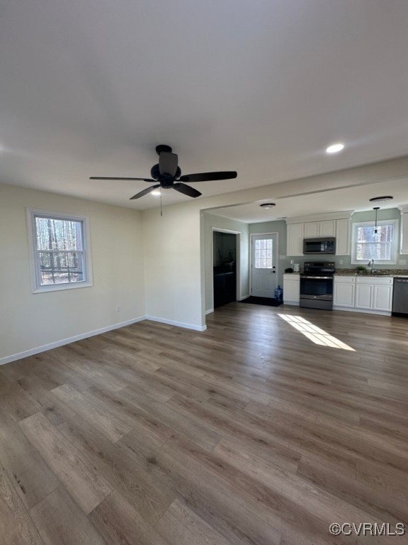 15810 Saddlebrook Road Chesterfield, VA 23838 - Photo 4 of 9 an empty room with wooden floor kitchen view and windows