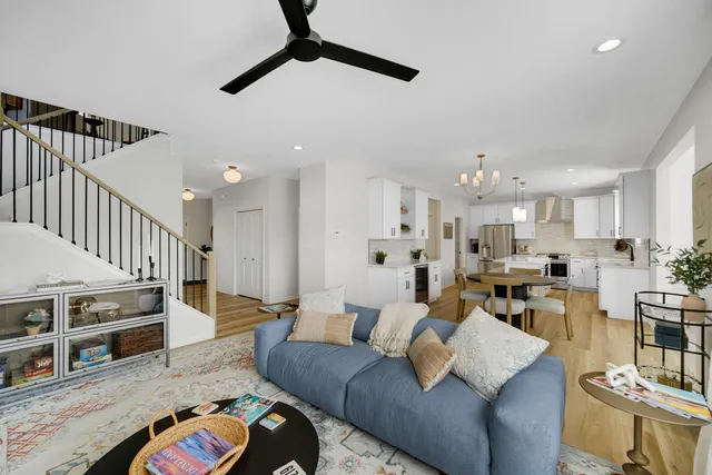 a living room with furniture kitchen view and a wooden floor