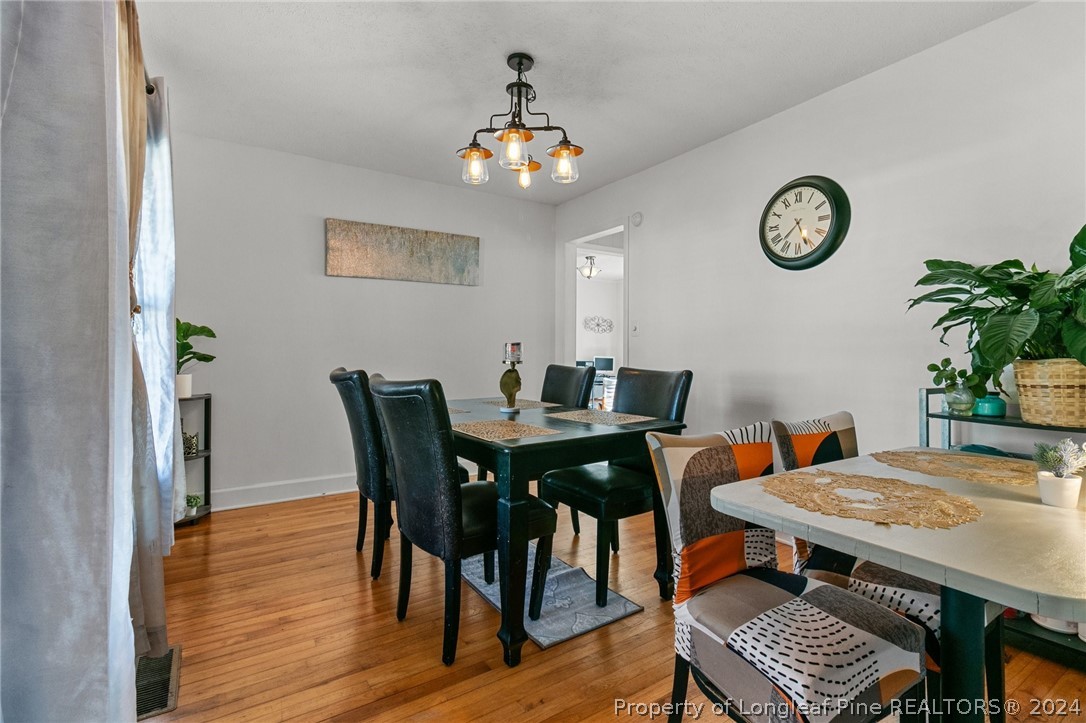 108 Mckinnon Drive Rockingham, NC 28379 - Photo 6 of 34 a dining room with wooden floor a chandelier a wooden table and chairs