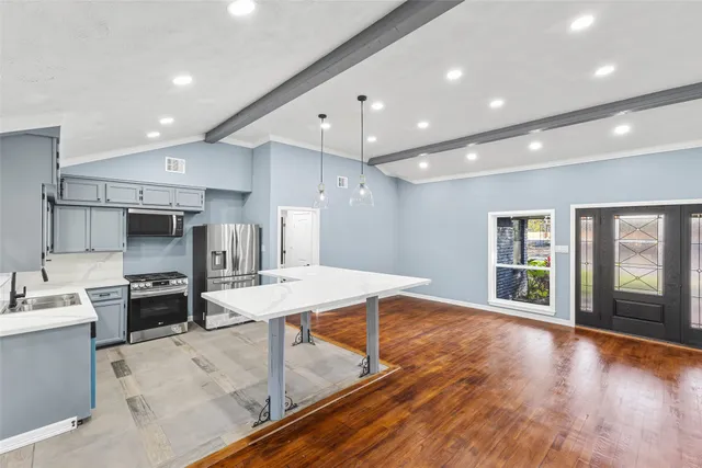 a large kitchen with kitchen island a sink stainless steel appliances and cabinets