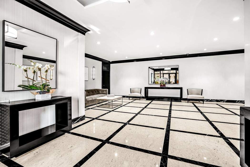 50 East 79th Street, Unit 5B Manhattan, NY 10075 - Photo 11 of 12 a living room with a bed furniture and a flat screen tv