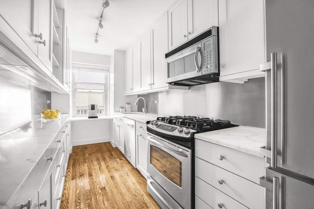 50 East 79th Street, Unit 5B Manhattan, NY 10075 - Photo 4 of 12 a kitchen with a stove a sink and a microwave