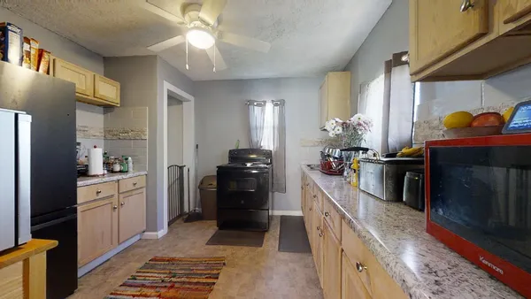 a kitchen with granite countertop a refrigerator stove and sink