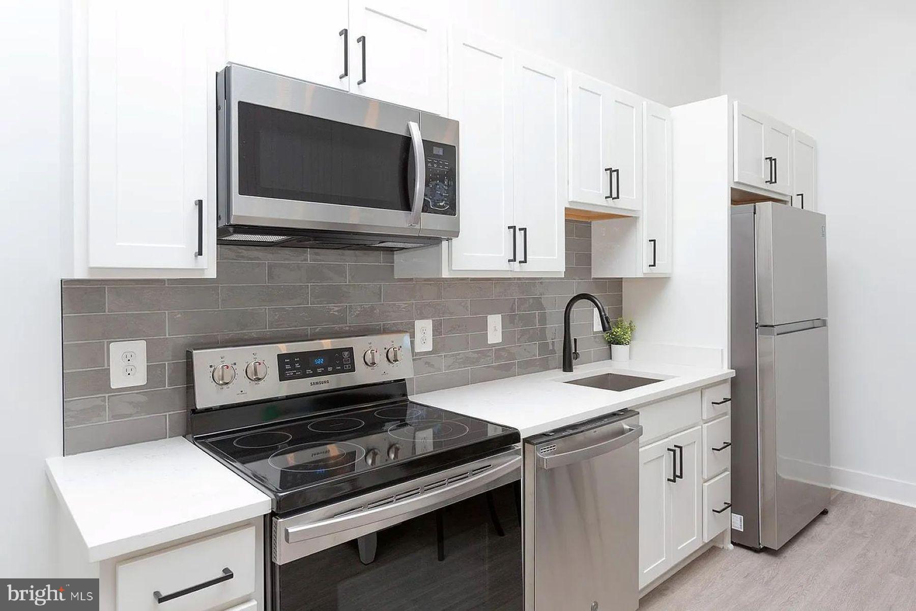 211 St Paul Street, Unit 504 Baltimore, MD 21202 - Photo 2 of 12 a kitchen with stainless steel appliances a stove microwave and sink