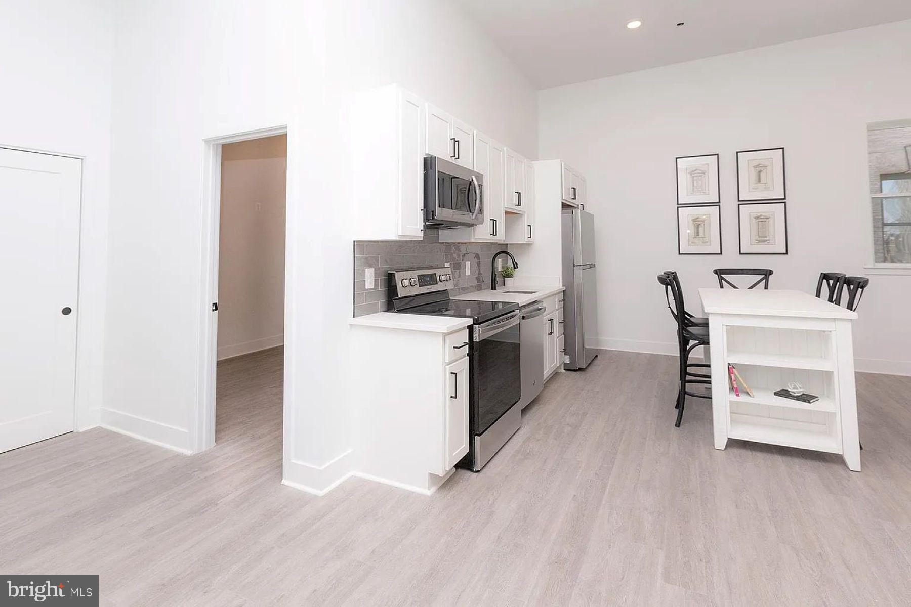 211 St Paul Street, Unit 504 Baltimore, MD 21202 - Photo 5 of 12 a kitchen with a sink cabinets and wooden floor