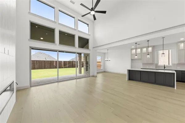 a view of an empty room with a window and kitchen view