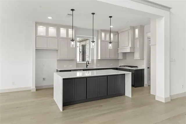 a kitchen with stainless steel appliances granite countertop a sink a stove and a refrigerator