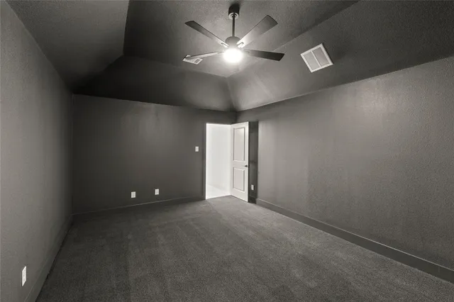 en empty room with a ceiling fan and window