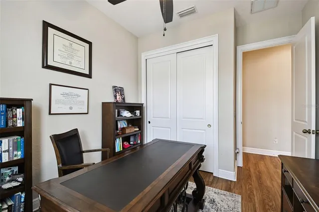 a view of multiple houses with a yard and palm trees