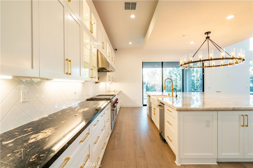 20043 Mersey Lane Porter Ranch, CA 91326 - Photo 11 of 68 a large kitchen with stainless steel appliances granite countertop a lot of counter space and wooden floor