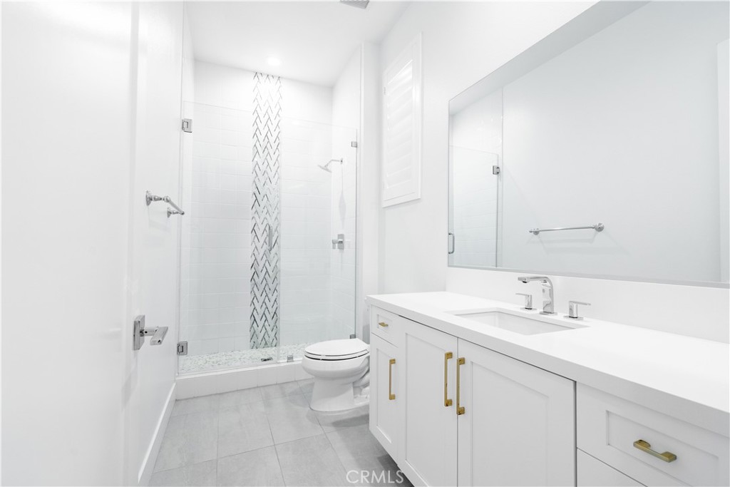 20043 Mersey Lane Porter Ranch, CA 91326 - Photo 27 of 68 a bathroom with a granite countertop sink a toilet and shower