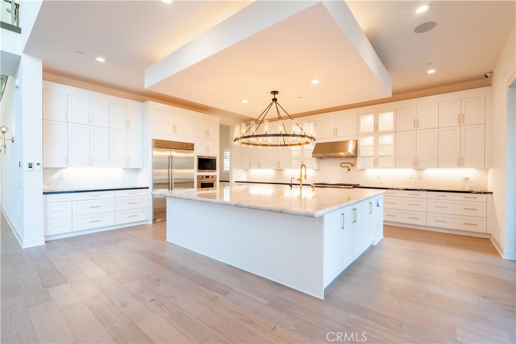 20043 Mersey Lane Porter Ranch, CA 91326 - Photo 8 of 68 a large kitchen with stainless steel appliances a large counter top and a window
