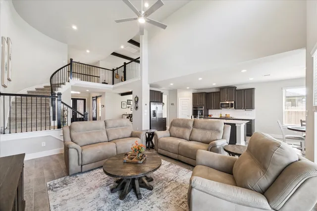 a living room with furniture kitchen view and a wooden floor