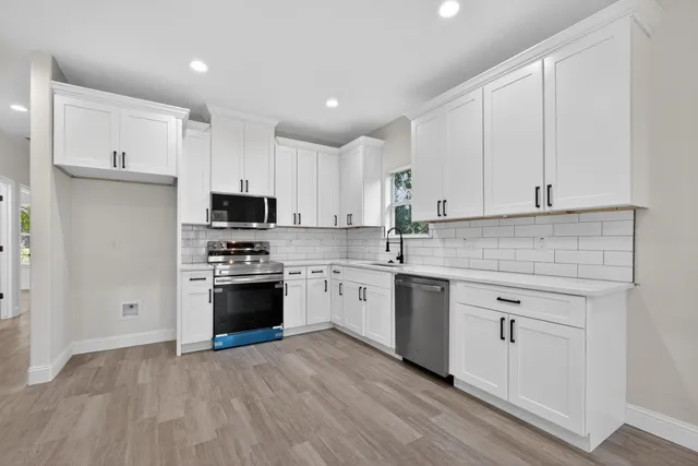 a kitchen with stainless steel appliances granite countertop a stove a sink and a microwave