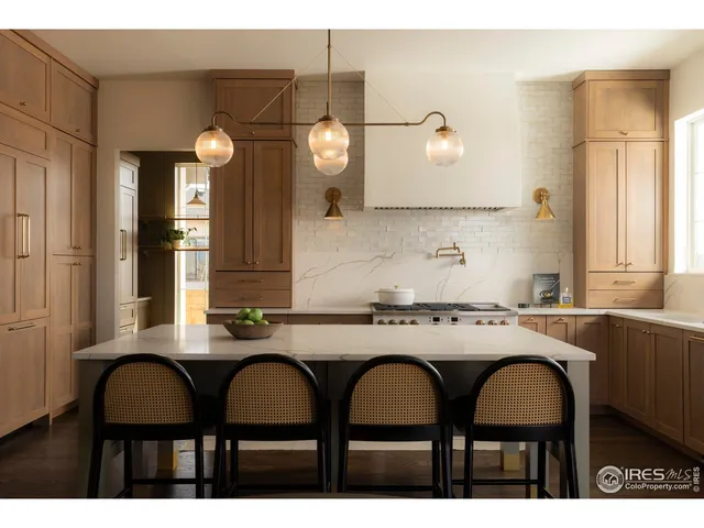 a kitchen with a dining table chairs cabinets and window