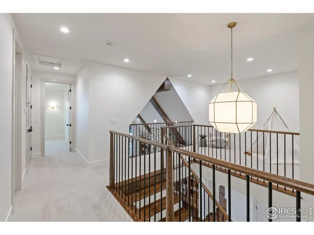 a view of staircase with railing and a chandelier