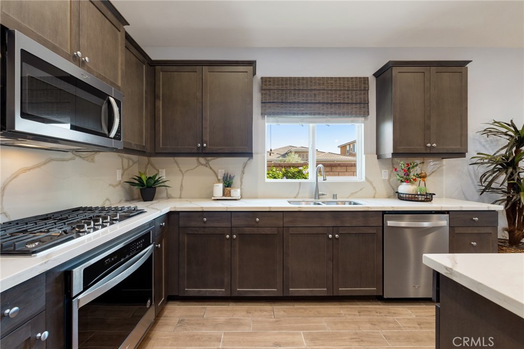 29981 Western Front Drive Menifee, CA 92584 - Photo 23 of 74 a kitchen with stainless steel appliances a stove a microwave a sink and cabinets