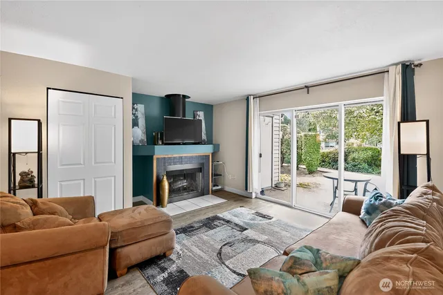a living room with furniture a large window and a fireplace
