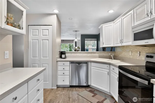 a kitchen with white cabinets stainless steel appliances and sink