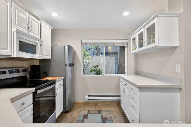 a kitchen with granite countertop a refrigerator stove and sink
