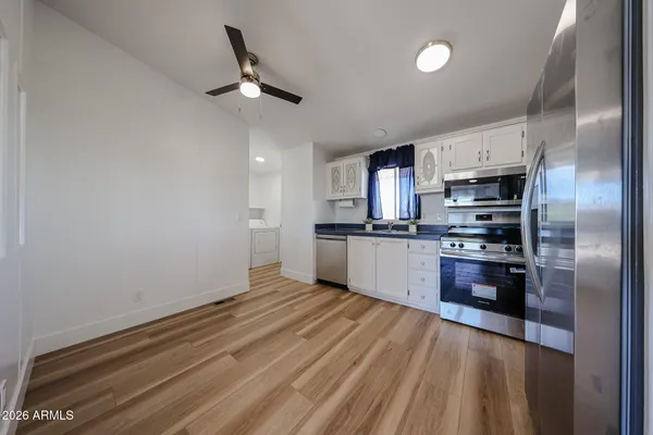 a kitchen with granite countertop a refrigerator a sink a stove and cabinets