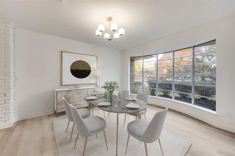 a dining room with furniture a chandelier and window