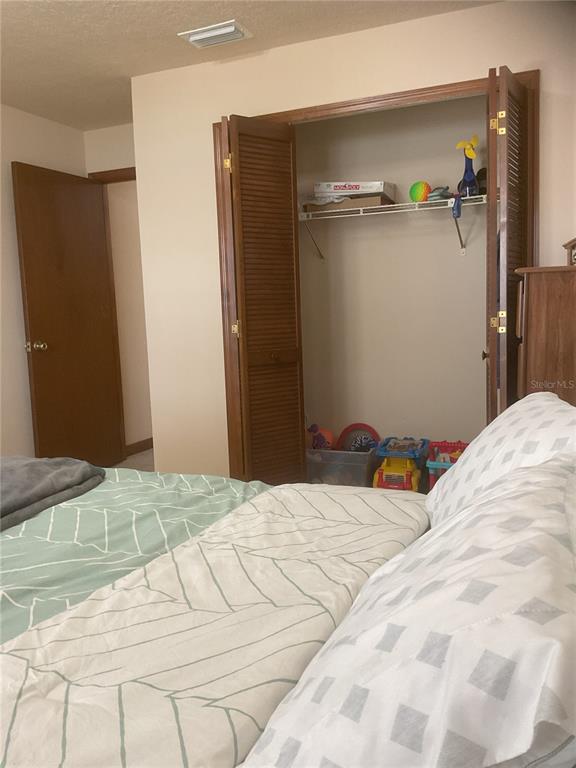 17005 Arrowhead Boulevard Winter Garden, FL 34787 - Photo 18 of 53 a bedroom with a bed and a table