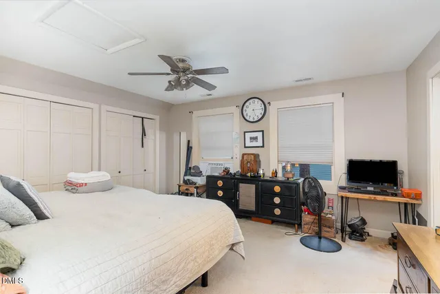 a bedroom with a bed a computer on a desk and dresser