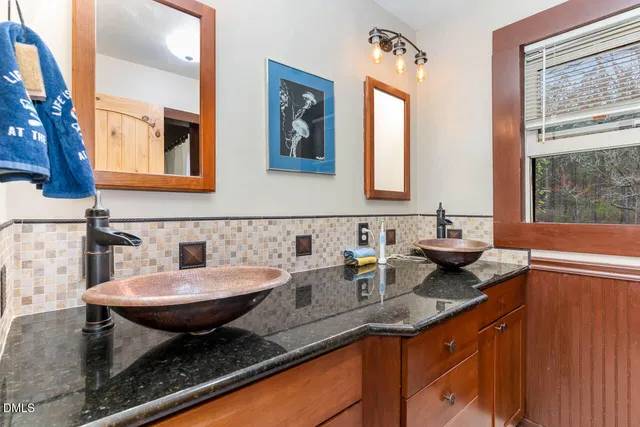 a bathroom with a granite countertop sink a large mirror and a window