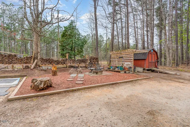 a view of pool with lawn chairs and large trees