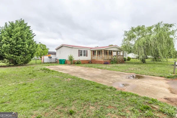 a view of house with yard and green space