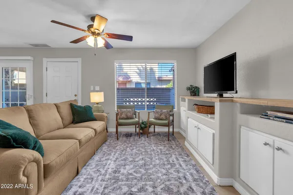 a living room with furniture a large window with kitchen view