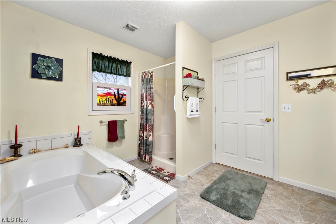 41038 Parsons Road Lagrange, OH 44050 - Photo 22 of 32 Bathroom featuring tile floors, separate shower and tub, and a textured ceiling