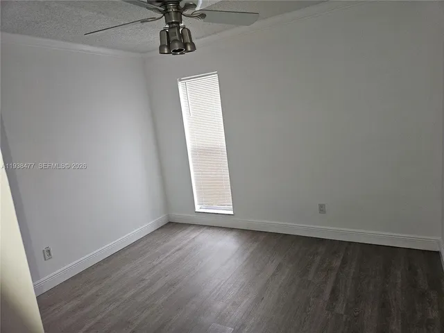 an empty room with wooden floor and chandelier fan